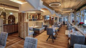 a restaurant with wooden floors and tables and chairs at Ferienwohnungen - Alpenhotel Fischer 4 Sterne - Adults Only in Berchtesgaden