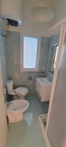 Un baño con dos inodoros, un lavabo y una bañera. en Arenella Sky and Sea, en Arenella 26 fotos más