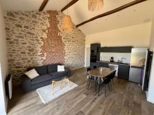 un salon avec un canapé et une table dans l'établissement La petite maison de campagne, à La Celle-sous-Gouzon