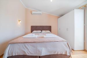 a bedroom with a large bed with two towels on it at Apartment Dragicevic 7 with Garage in Budva