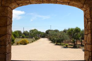 a pathway through an archway in a park at La Rosa dei Venti in Alghero