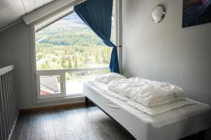 a bed in a room with a large window at Hemsedal Cafe Skiers Lodge in Hemsedal