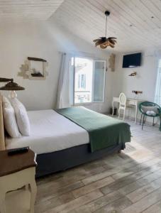 a bedroom with a large bed and a window at Chambre d'hôtes Hôte des Portes Île de Ré in Les Portes