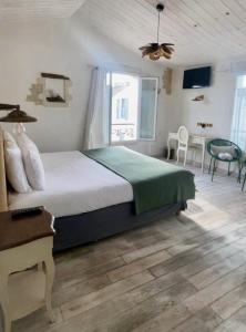 a bedroom with a bed and a table and a window at Chambre d'hôtes Hôte des Portes Île de Ré in Les Portes