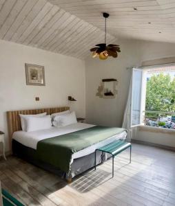 a bedroom with a large bed and a window at Chambre d'hôtes Hôte des Portes Île de Ré in Les Portes