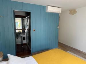 a room with a blue wall with a bed in it at Chambre d'hôtes Hôte des Portes Île de Ré in Les Portes