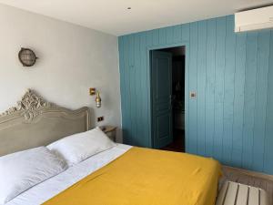 a bedroom with a bed and a blue wall at Chambre d'hôtes Hôte des Portes Île de Ré in Les Portes