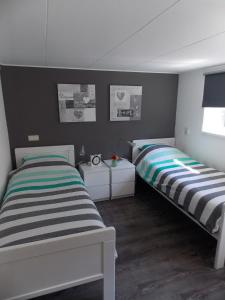 two twin beds in a room with at Bed and breakfast de Boerderij in Albergen