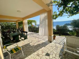 a patio with a table and chairs with a view at Guest House Donatela in Valun