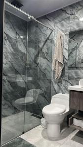 a bathroom with a toilet and a glass shower at House Trail Lyones in Choachí