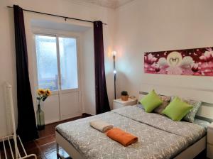 a bedroom with a bed with green pillows and a window at Perfect Room Near Airport 1 in Lisbon