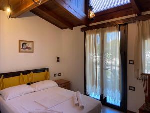 una camera da letto con un letto e una grande finestra di Hotel The First a Gjirokastër Altre 37 foto
