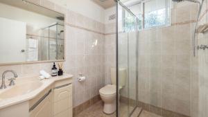 a bathroom with a shower and a toilet and a sink at Sandy Point Escape in Corlette +20 photos