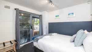 a bedroom with a bed and a large window at Sandy Point Escape in Corlette