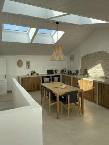 a kitchen with a table and chairs in a room at Chambre d'hôtes Hôte des Portes Île de Ré in Les Portes