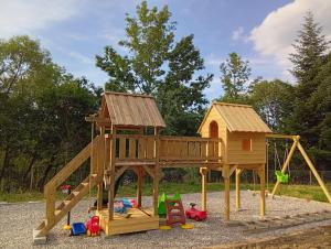 a wooden playground with a play house and toys at Bobrí potôčik in Liptovský Mikuláš