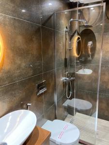 un bagno con due lavandini e una doccia di Hotel The First a Gjirokastër