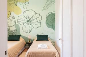 two beds in a room with flowers on the wall at Fliphaus Mansion Paz A 10 pax Deluxe House Belgrano in Buenos Aires