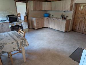 a kitchen with wooden cabinets and a table and a sink at LAMPAREULA - ლამპარეულა in Zhabeshi