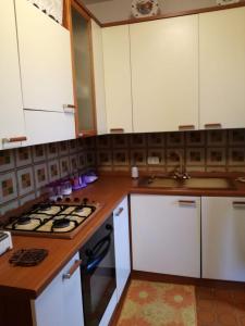 a kitchen with white cabinets and a stove top oven at La casa al mare int2 in Lido Di Fondi