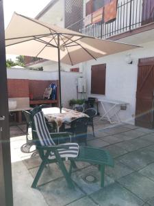 a table and chairs with an umbrella on a patio at La casa al mare int2 in Lido Di Fondi