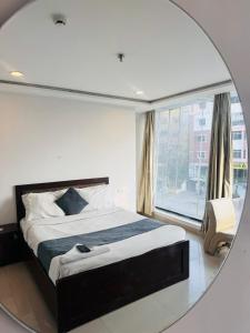 a mirror reflecting a bedroom with a bed and a window at Wild Wings Hotel in Hyderabad +5 photos