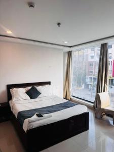 a bedroom with a large bed and a large window at Wild Wings Hotel in Hyderabad