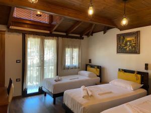 una camera da letto con due letti e una finestra di Hotel The First a Gjirokastër