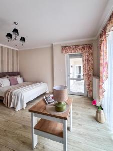 a bedroom with a bed and a table with a coffee table at Dom Wczasowy Natalia in Łeba