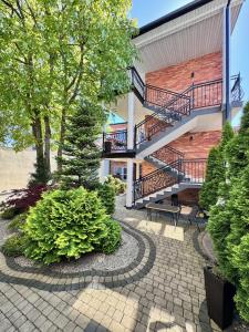 a brick building with a staircase and a patio at Dom Wczasowy Natalia in Łeba