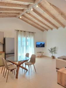 a dining room with a glass table and chairs at Villa Eleni Apartment no2 in Agios Gordios