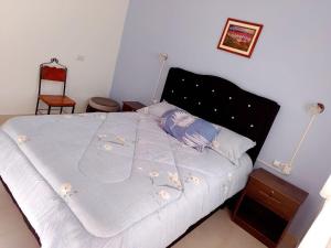 a bedroom with a bed with a blue comforter at La Candelaria in Humahuaca +5 photos