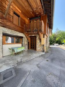 a building with a bench and a balcony on it at Joli logement au calme in Vésonne