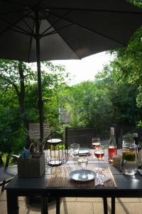 a table with glasses of wine and an umbrella at Mirtusz Vendégház in Verőce