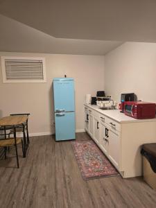 a kitchen with a blue refrigerator and a table at The Peaceful Lower Loft in Winnipeg
