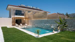 a villa with a swimming pool in front of a house at Casa Meis Villas & ESCAPES in Kaş