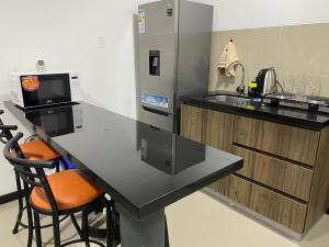a kitchen with a counter with a sink and a refrigerator at Confortable discreto y resort in Santa Cruz de la Sierra