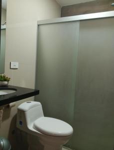 a bathroom with a white toilet and a sink at Confortable discreto y resort in Santa Cruz de la Sierra