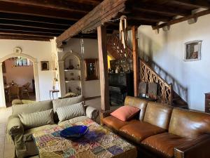 a living room with a leather couch and a table at Painter's House Historic Stone Villa with Sea View in Perast