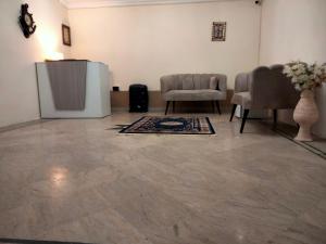 a room with a television and chairs and a rug at Dazzy Dream Guest Houses in Islamabad