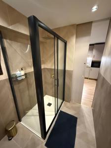 a bathroom with a glass shower with a blue rug at Salou Vars Rafayel in Salou