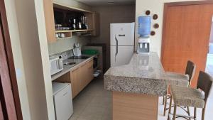 a kitchen with a refrigerator and a table with chairs at Beachfront Ap 314 Kariri Beach in Caucaia