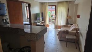 a kitchen with a counter top and a living room at Beachfront Ap 314 Kariri Beach in Caucaia