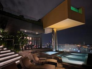 a building with a swimming pool at night at The Edge Central Pattaya - Unique & Luxurious in Pattaya Central