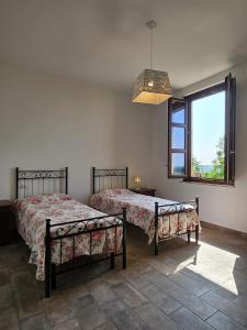 a bedroom with two beds and a window at Borgo Amarrante in Montaione