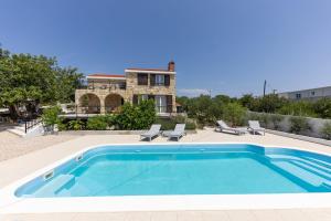 a swimming pool in front of a house at Villa Mellifera in Grohote