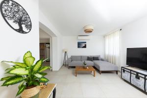 Una sala de estar con un sofá y un televisor. en Villa Mellifera, en Grohote