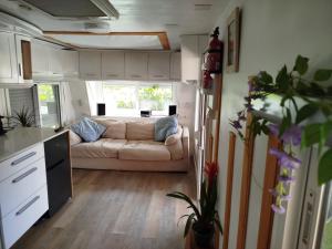 a living room with a couch in a tiny house at Caravana en la huerta in Tiñosa Alta
