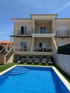 a villa with a swimming pool in front of a house at Luxury 6BR Villa Private Pool & Games Room Sleeps 12 in Quarteira