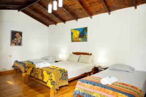 two beds in a room with white walls and wooden floors at La Viña de OsCar in Nuevo Imperial